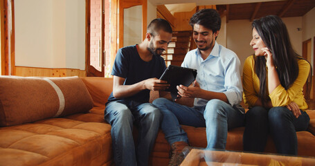 Discussion of Indian friends around the table while looking at the tablet