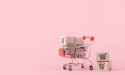 Shopping concept : Cartons or Paper boxes in red shopping cart on pink background. online shopping...