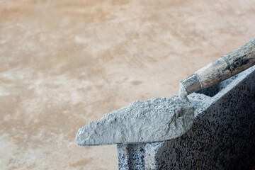 Cement powder or mortar with  trowel put on the Concrete brick for construction work..