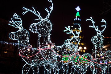 Lighting decoration deers with christmas tree on the background in the city of Gomel during New Year festival celebration.