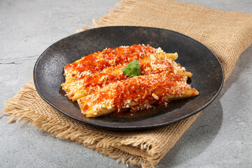 Pancakes stuffed with minced meat and topped with tomato sauce and grated cheese.