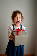  Happy laughing child girl with Christmas gift at home. Christmas surprise. Christmas holidays concept, New Years Eve