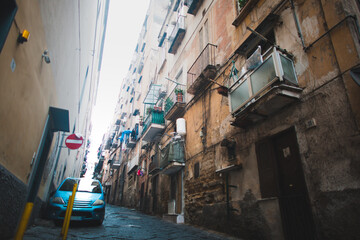 Naklejka na ściany i meble Scenic view of typical narrow alleyway lined with scooters and laundry lines in the Medieval Centro Storico of Naples, Italy