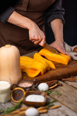 Cooking the famous American pumpkin pie A cook slices the pumpkin to make the pie filling. Close-up. Ingredients. Restaurant, hotel, cafe, home cooking, cooking blog.