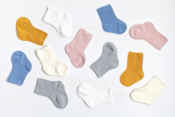 Collection of cute colored baby socks for little feet. Warm socks for cold weather of fall and winter season. Top view, flat lay background.