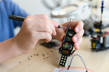 Kid inventor assambling radio control robot. Close up Holding tools and DIY robot