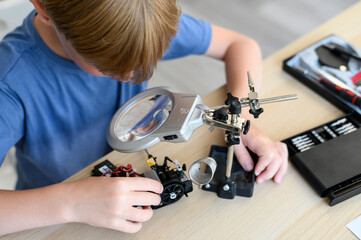 Top view table with Kid inventor assambling radio control robot