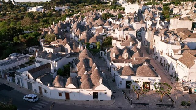 Aerial view of trulli of alberobello town in Italy. drone fly over old town buildings at sunrise
