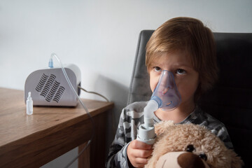 Fototapeta Niezadowolony chłopiec robiący inhalacje. obraz