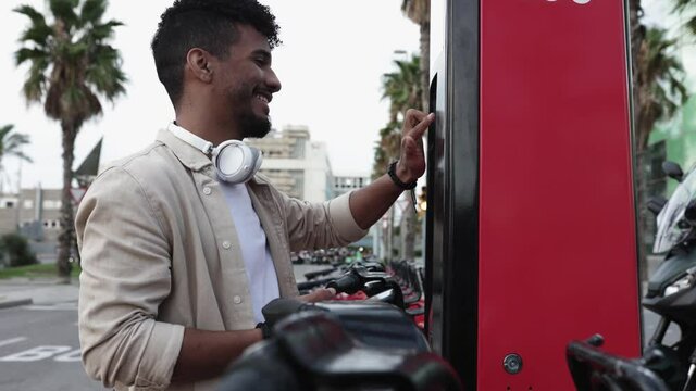 Young hipster man renting a bike through mobile phone app in the city - Eco transportation and commuting concept. High quality 4k footage