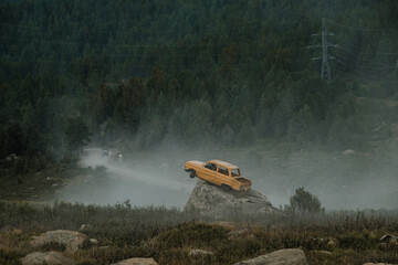 An old car stands on a stone near the Valentin's outpost in the Ulagan Pass in the Republic of Altai