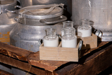Milk bottles in a wooden box. Aluminum cans. Straw.