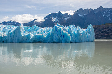 Grey glacier reflection by grey lake with Andes mountain peaks, Torres del Paine, Patagonia, Chile.
