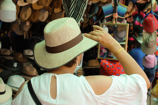 Mujer con sombrero mir&aacute;ndose al espejo