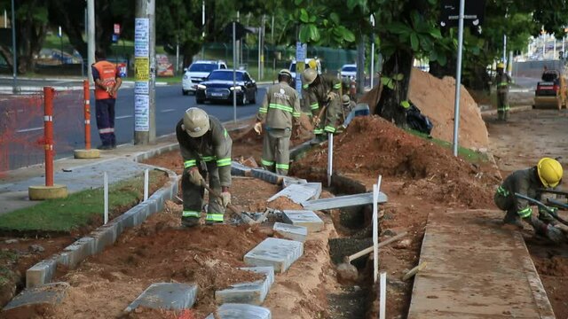 salvador, bahia, brazil - may 26, 2021: civil construction workers are seen during construction of an exclusive lane for the transit of vehicles of the BRT system in the city of Salvador.