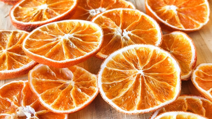 Dried orange slices on the wooden table. Dry citrus. Dried citrus fruits on the table. Orange slices top view. Still life citrus fruits photography.