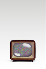 An old fashion television on a white background with noise on the screen.