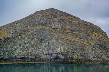 Stykkisholmur, Iceland: Columnar basalt rock formation of a small island in the waters of the Breidafjordur, created by volcanic eruption.