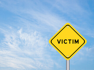 Yellow transportation sign with word victim on blue sky background