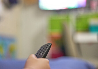 Hand use remote control tv for change channels in living room