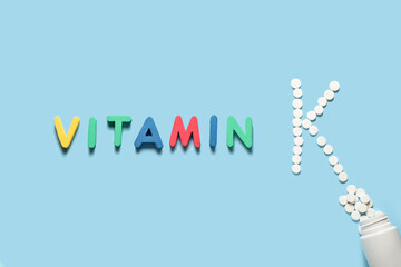 Fototapeta premium Word VITAMIN and letter K made of pills on color background