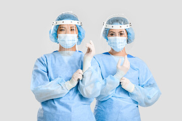 Portrait of female Asian surgeons on light background