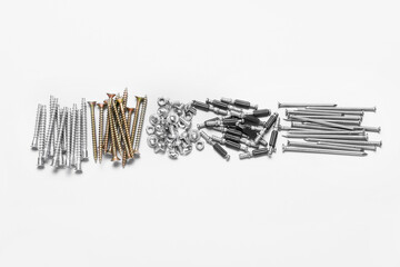 Piles of bolts screws and nails on white background