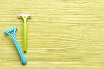 Safety razors on color wooden background