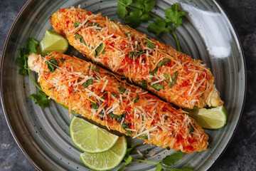 Plate with tasty Elote Mexican Street Corn on black background