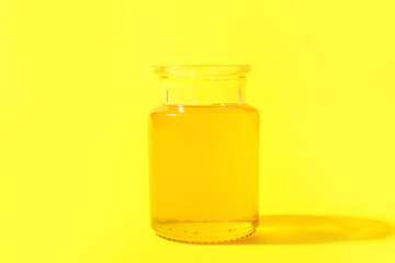 Jar of sweet honey on yellow background