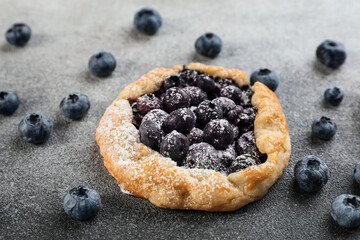 Tasty blueberry galette on black and table, closeup