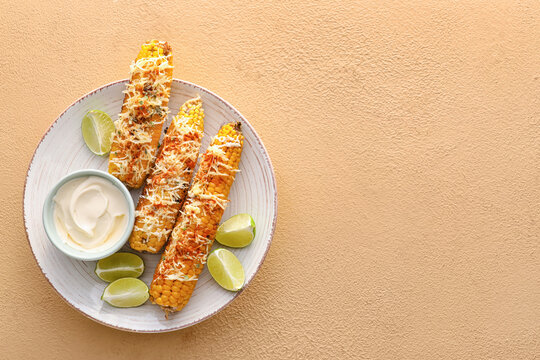 Plate with delicious Elote Mexican Street Corn and mayonnaise on beige background
