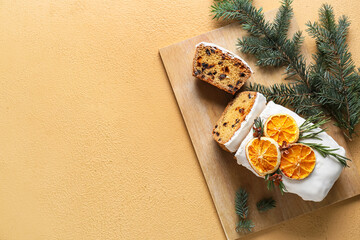 Board with tasty Christmas stollen on color background