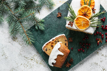 Board with tasty Christmas stollen on light background