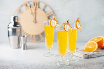 Festive Alcohol cocktail Mimosa with Orange juice and cold Champagne or sparkling Wine in glasses...