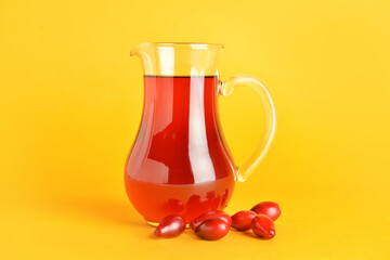 Jug of healthy dogwood berry drink on color background © Pixel-Shot