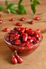 Bowl of sweet dogwood jam on wooden background