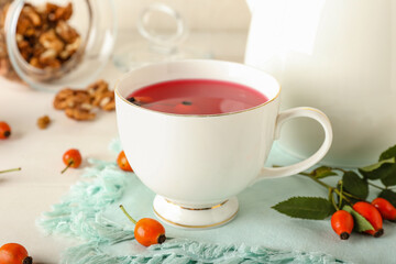 Obraz na płótnie Canvas Cup of tasty rose hip tea and berries on table
