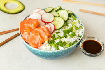 Tasty poke bowl and sauce on light background