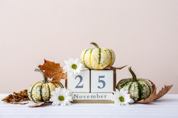 Festive autumn composition with pumpkins and calendar on light table