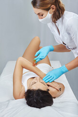 Depilation and epilation female arm with liquid sugar paste. Hand of cosmetologist applying wax paste on armpit. Smooth arm concept