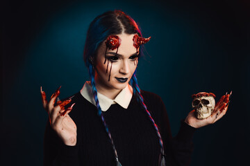 woman with scary halloween makeup with bloody horns dark background