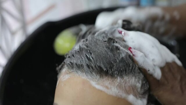 Hermosa mujer joven en un sal&oacute;n de belleza lavando su cabello con un profesional del sal&oacute;n, concepto de estilo de vida y cuidado personal. Primer plano	