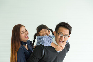 Happy Asian family having fun with home. Asian father playing and carrying little daughter on back at home with happy and smile