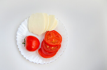 Vegetables tomatoes cut into rings and homemade salted cheese on a white background. Healthy food.