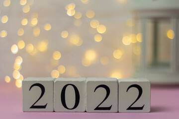 Happy New Year 2022.On a wooden perpetual calendar with a blurred abstract background with a bokeh with copy space.