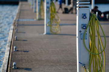 Charging station for boats, electrical outlets to charge sailboats in empty harbor of marina