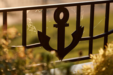 Decorative black metal anchor on the fence of the river port © V_Saratovtseva