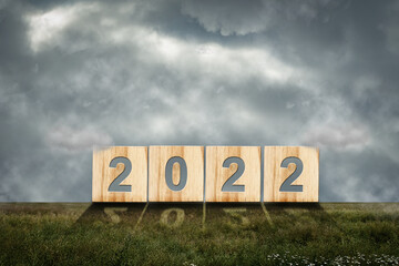 2022 on a wooden block against a cloudy sky. New Year concept. Festive background.