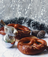 baked pretzels with christmas decorations side view on shiny background closeup. Selective focus
